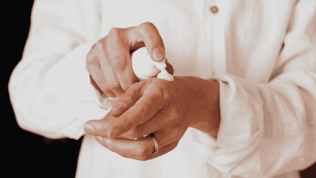 Person applying a small amount of cream to their fingertip, demonstrating proper diltiazem cream application