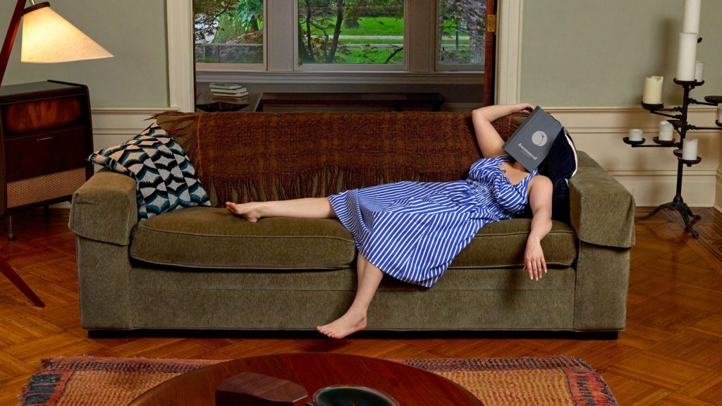 Woman resting comfortably on a couch while managing anal fissure symptoms at home